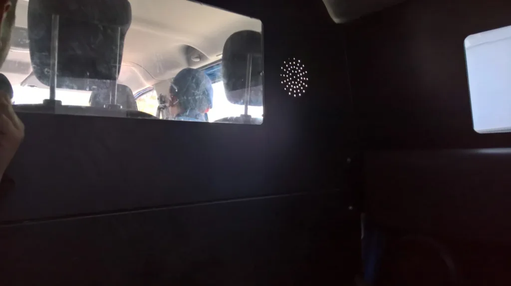 Back view of a police officer who arrested Juan Carlos, seen from the back of the police car